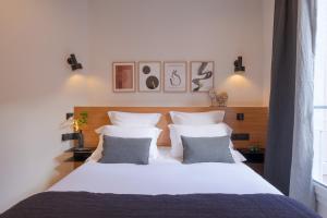 巴黎Tinah Paris, Aboukir的卧室配有一张带两个枕头的大白色床