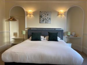 因弗内斯艾道斯格伦凯恩酒店的卧室配有一张带两个绿色枕头的大型白色床