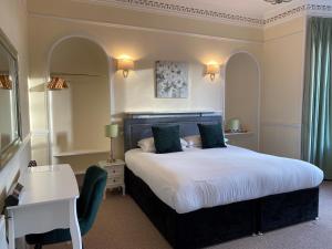 因弗内斯艾道斯格伦凯恩酒店的酒店客房设有一张大床和一张书桌。