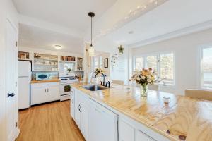 普里茅斯Heavenly Lakefront的厨房配有白色橱柜和木制台面