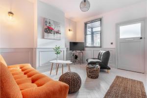 赫里福德Guest Homes - Barton Road Retreat的客厅配有橙色沙发和椅子