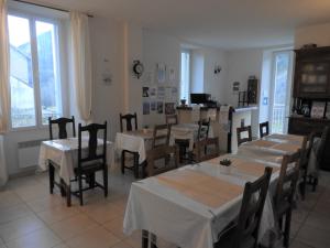 Villeneuve-dʼEntraunesLe Relais des Cavaliers的用餐室设有桌椅和窗户。