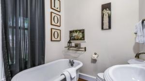 KingsvilleThe Woodbridge House的白色的浴室设有浴缸和水槽。