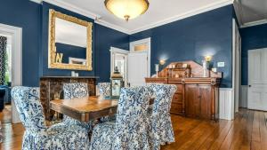 KingsvilleThe Woodbridge House的一间拥有蓝色墙壁和一张木桌及椅子的用餐室