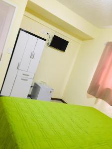 埃斯特角城Hotel La Vista 32的一间卧室配有绿色的床和电视