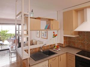 帕尔斯Casa adosada en Platja de Pals by Apartaments Golf的厨房配有木制橱柜、水槽和窗户。