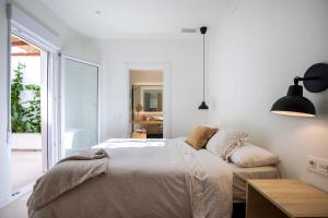 莫利纳德塞古拉Agradable casa con patio interior.的白色的卧室设有床和大窗户