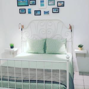 大加那利岛拉斯帕尔马斯Little Surf House Hostel的一张带绿色枕头的白色床和墙上的照片
