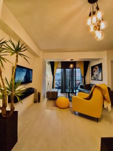 什蒂普Sandev Apartments的一间客厅,配有黄色的沙发和棕榈树