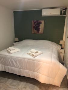 卢汉德库约De Los Andes Hotel Boutique的卧室配有白色的床和2条毛巾
