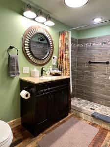 圣伊尼亚斯Moosewood Inn的浴室配有盥洗盆和带镜子的淋浴