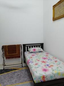 关丹HOMESTAY KUANTAN INDERA SEMPURNA 2的卧室配有一张床,墙上挂着一幅画