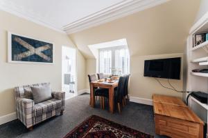 因弗内斯Luxury Inverness central apartment private parking的客厅配有桌椅和电视。