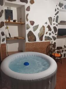 洛斯雷亚莱霍斯Casita Rural con Jacuzzi climatizado.的一个带桌椅的客房内按摩浴缸