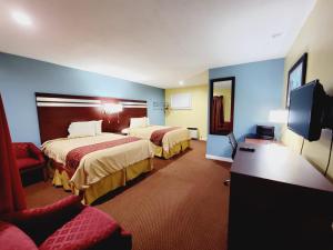威廉斯堡巴塞特汽车旅馆的酒店客房设有两张床和一台平面电视。