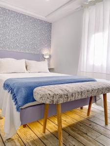 塞辛布拉Filipe Village - Casa da Índia的一间卧室配有一张带蓝色毯子和长凳的床