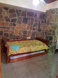 伊瓜苏港Apart JM的石墙房间内的一张床位