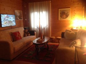 科拉欣塔拉山间小屋的客厅配有两张沙发和一张桌子