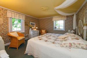 拉马巴耶维多利亚住宿酒店的一间卧室设有一张大床和两个窗户。