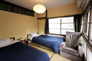 广岛广岛上佳旅馆 的一间卧室设有两张床、一把椅子和一个窗户。