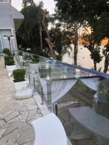 伊加拉塔Pousada Paraiso de Igaratá的露台上的玻璃桌子和椅子