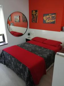 布宜诺斯艾利斯Premium Down Town的一间卧室设有两张带红色墙壁和镜子的床