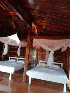Tân PhúFOREST BREATH ECO-LODGE的配有木天花板的客房设有两张床。