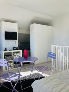 滨海苏拉克Grand appartement 1ch vue Océan的配有桌子和两把椅子及一张床的房间