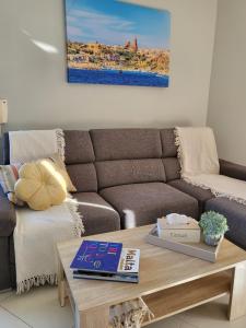 艾因西莱姆Ir-Rixa Holiday Penthouse的带沙发和咖啡桌的客厅