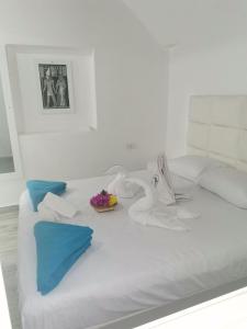 沙姆沙伊赫Sunshine Divers Club - Il Porto的一张白色的床,上面放着一碗鲜花