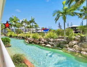 亚历山德拉岬角Resort Queen Studio at Alex Beach Resort的一条拥有岩石和棕榈树的河流