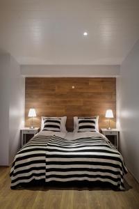 塞尔福斯梭里斯同公寓的一间卧室配有一张黑色和白色条纹的大床
