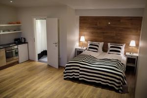 塞尔福斯梭里斯同公寓的一间卧室配有一张带木制床头板的床