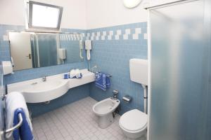 里米尼Hotel Villa dei Fiori - sul mare con piscina的蓝色瓷砖浴室设有卫生间和水槽