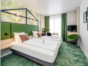 汉诺威汉诺威米特美居酒店的酒店客房设有两张床和电视。