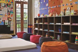 巴姆博利姆果阿君悦酒店的儿童间设有床、椅子和书架