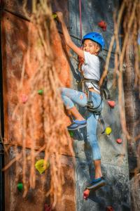 巴姆博利姆果阿君悦酒店的一个小男孩正在攀岩
