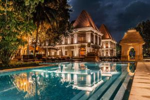 巴姆博利姆果阿君悦酒店的一座大房子,前面设有一个游泳池