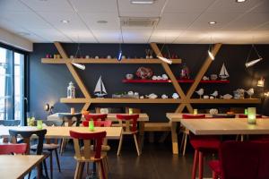 科尔马科尔马酒店 的用餐室配有木桌和红色椅子