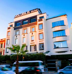 梅克内斯Hôtel Volubilis Meknès的前面有棕榈树的建筑