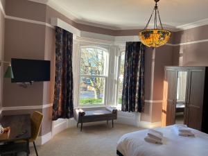 南安普敦伊丽莎白别墅酒店的一间卧室设有一张床、一个窗户和一个吊灯。