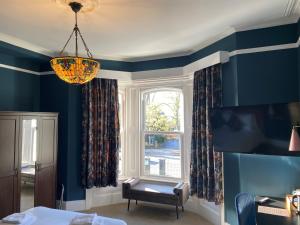 南安普敦伊丽莎白别墅酒店的客厅设有蓝色的墙壁和窗户。