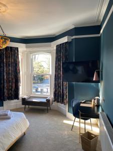 南安普敦伊丽莎白别墅酒店的一间卧室配有一张床、一张书桌和一个窗户。