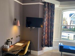 南安普敦伊丽莎白别墅酒店的客房设有书桌和带电视的窗户。