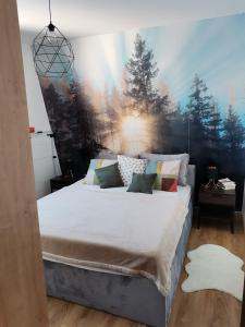 亚霍里纳Apartmani Kamavu的卧室配有一张大床,墙上挂有绘画作品