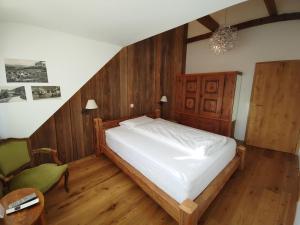 NunningenLandgasthof Roderis的一间卧室配有一张床和一把绿色椅子