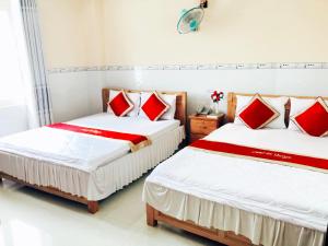 Cao LãnhDe Vuong 2的配有白色和红色枕头的客房内的两张床