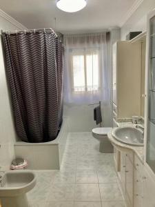 Hontoria del PinarCASA RURAL COSTALAGO的浴室设有2个水槽和1个淋浴帘