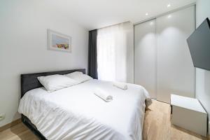 博索莱伊Frontière Monaco, Terrasse, Vue Mer, Parking - AB的卧室配有白色的床和窗户。
