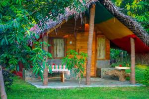锡吉里亚Elephant Lake Villa的茅草屋顶和长凳的木屋